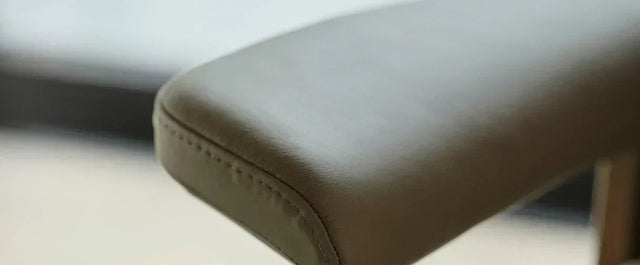 Close-up van het lederen armleuning-detail van een Stressless relaxfauteuil, met zichtbare stiknaad.