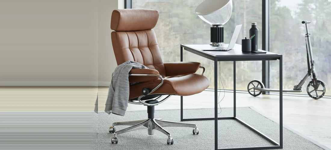 Stressless London high back Office in Paloma Henna-leder op een chromen office-onderstel aan een zwart bureau bij een raam
