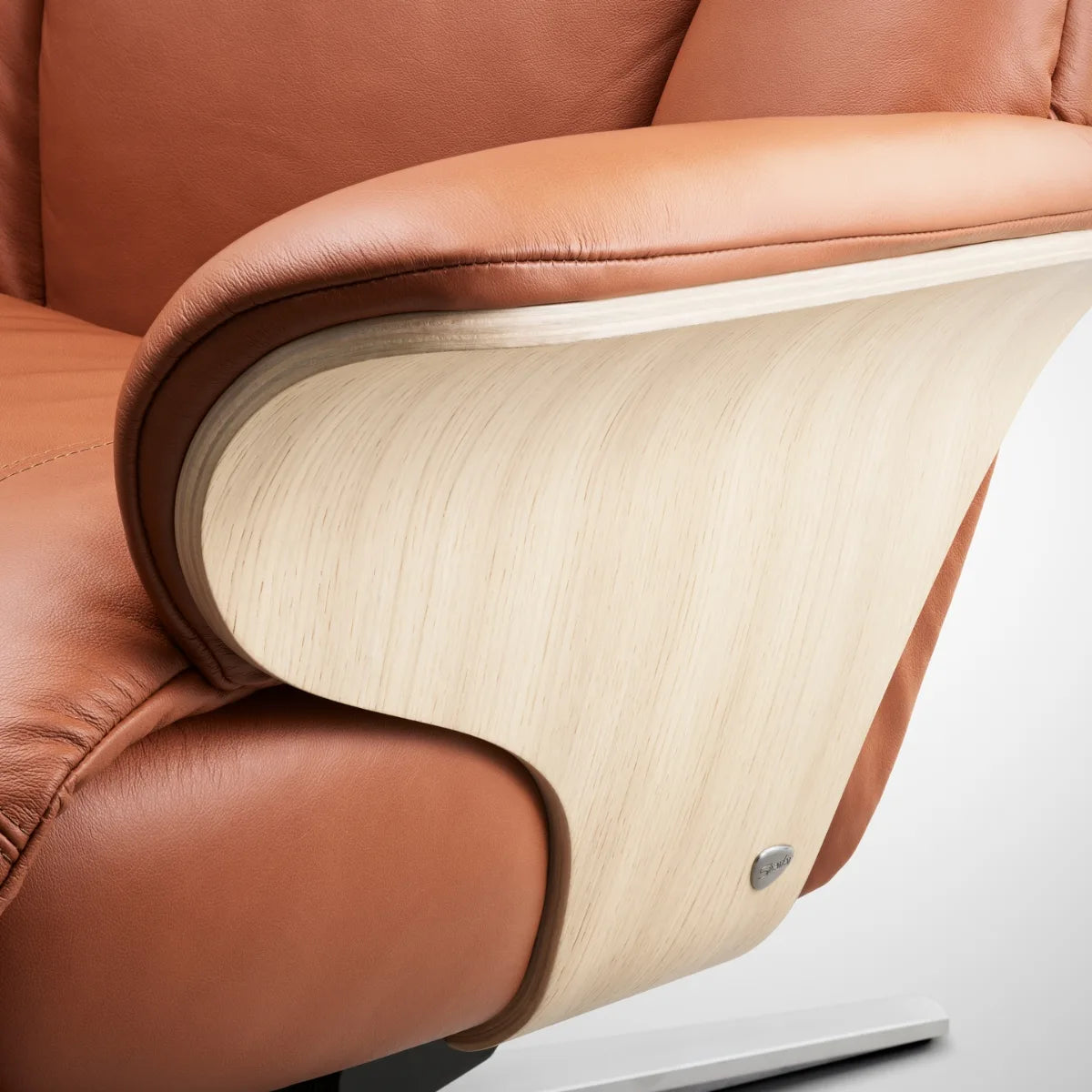Close-up of the wooden side panels around the seat of a Stressless Adam in Paloma New Cognac leather