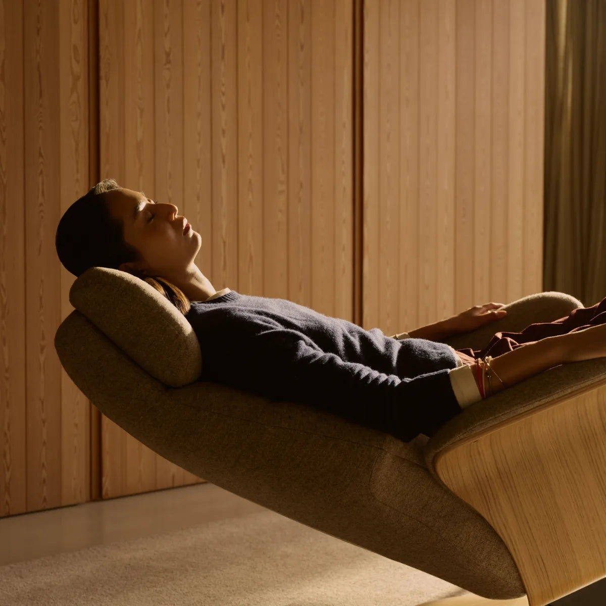 A man lies completely relaxed in the Zero Gravity position of a Stressless Adam upholstered in Clover Funghi fabric, with his legs elevated above his heart