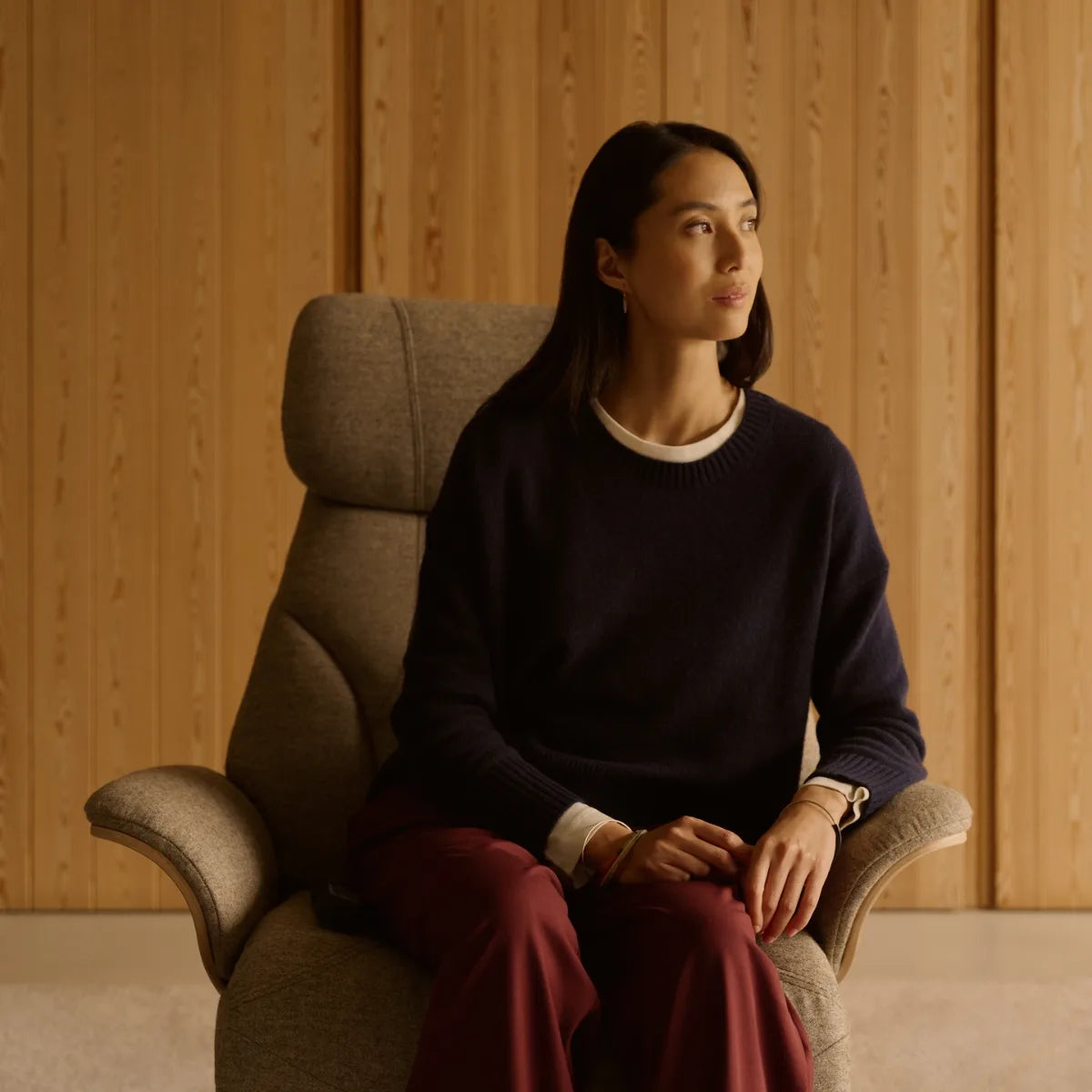 A woman is sitting upright in a Stressless Adam, with her feet flat on the floor thanks to the 51-centimeter seat height