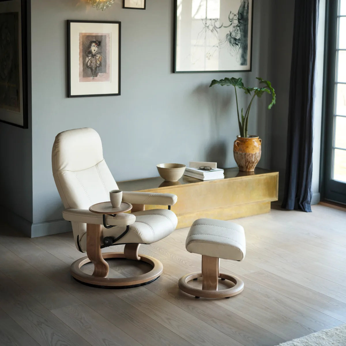 Stressless Consul Classic in cream Batick leather on an oak base in a living room with paintings