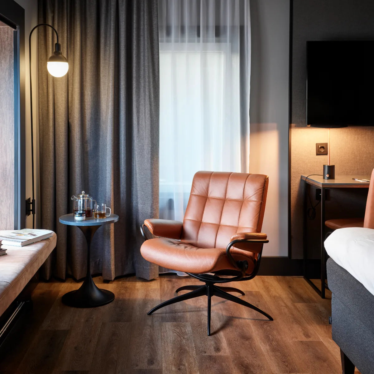 Stressless London in cognackleurig leder in een warm verlichte kamer met houten vloer