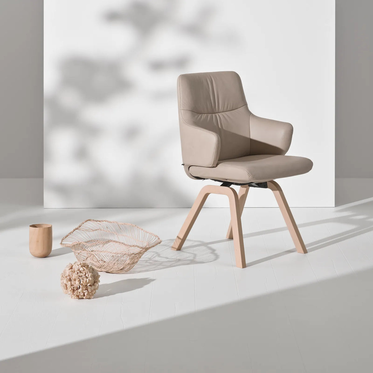 Stressless Mint dining chair with a low back and armrests in light gray Paloma leather on a D200 base in whitewash