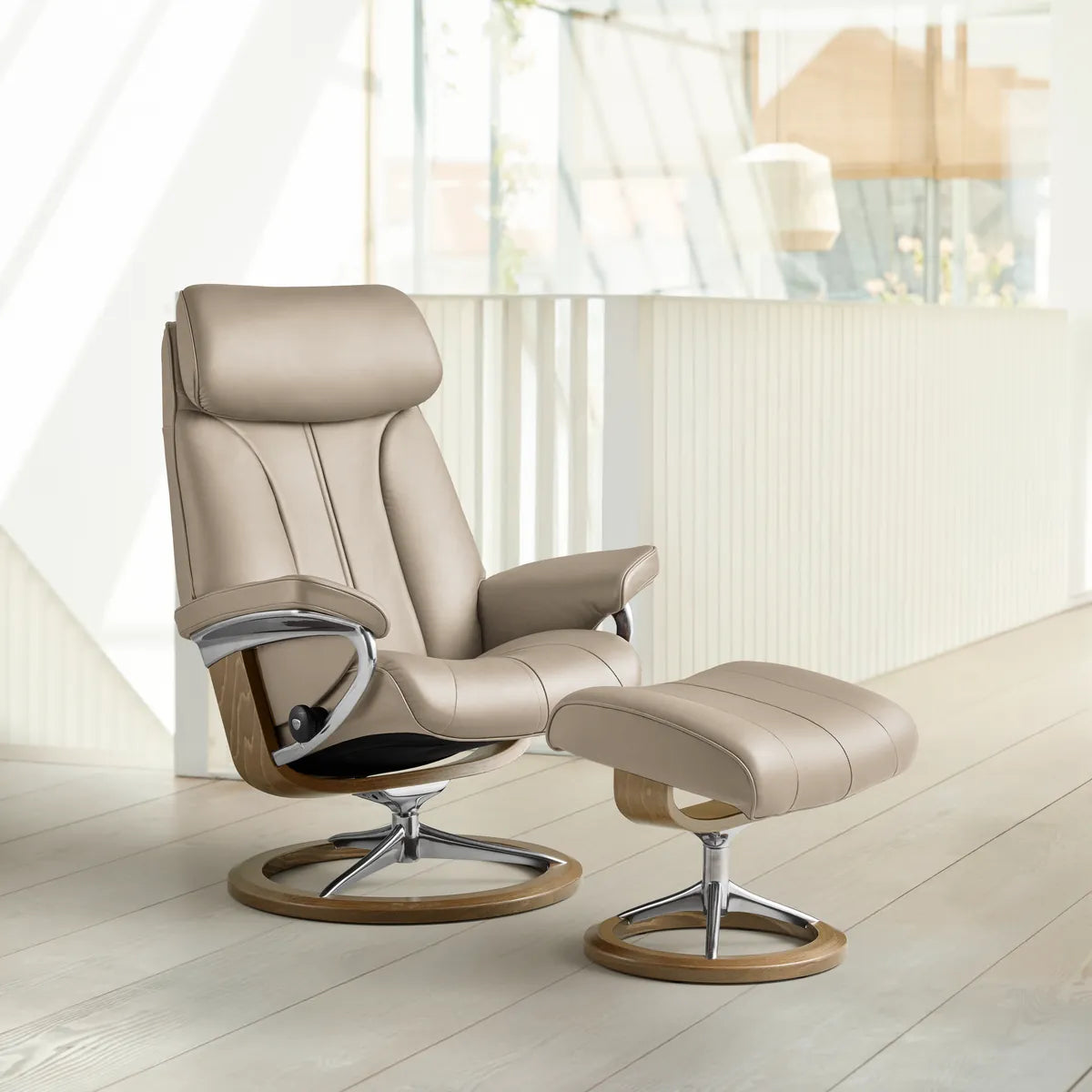 Stressless Paul with footstool in Velaro Light Grey leather on a Signature base in oak, side view of the tall wing-shaped backrest