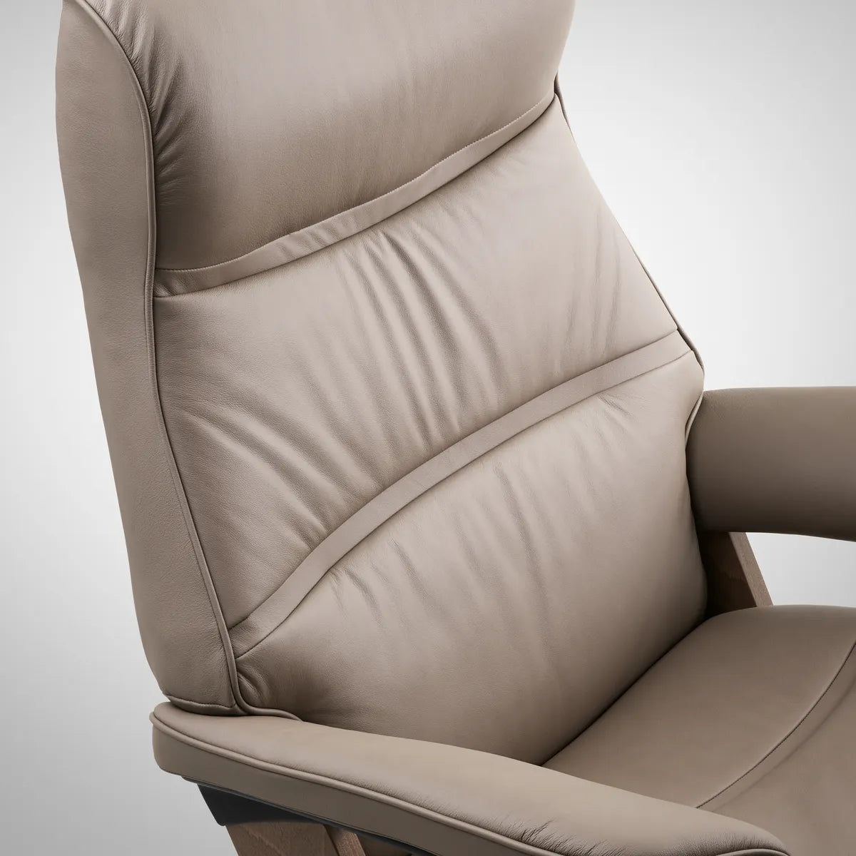 Close-up of the curved wingback with its distinctive stitching and piping on the Stressless Philip in Paloma Dark Mushroom leather