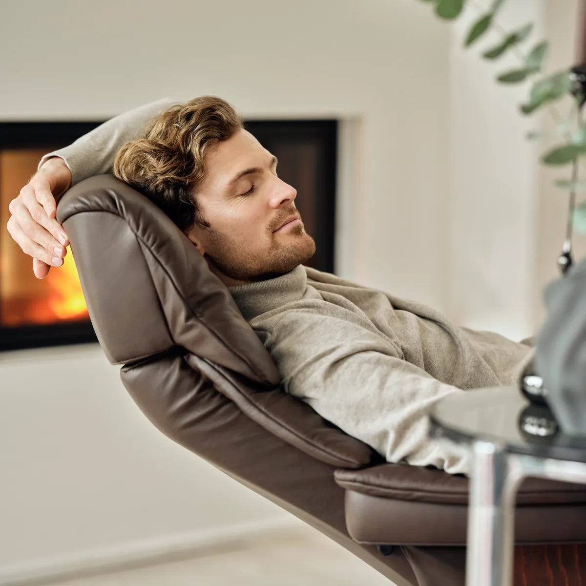 Man leunt ontspannen achterover met zijn hoofd tegen de zachte hoofdsteun van een Stressless Ruby in Paloma Chocolate leder