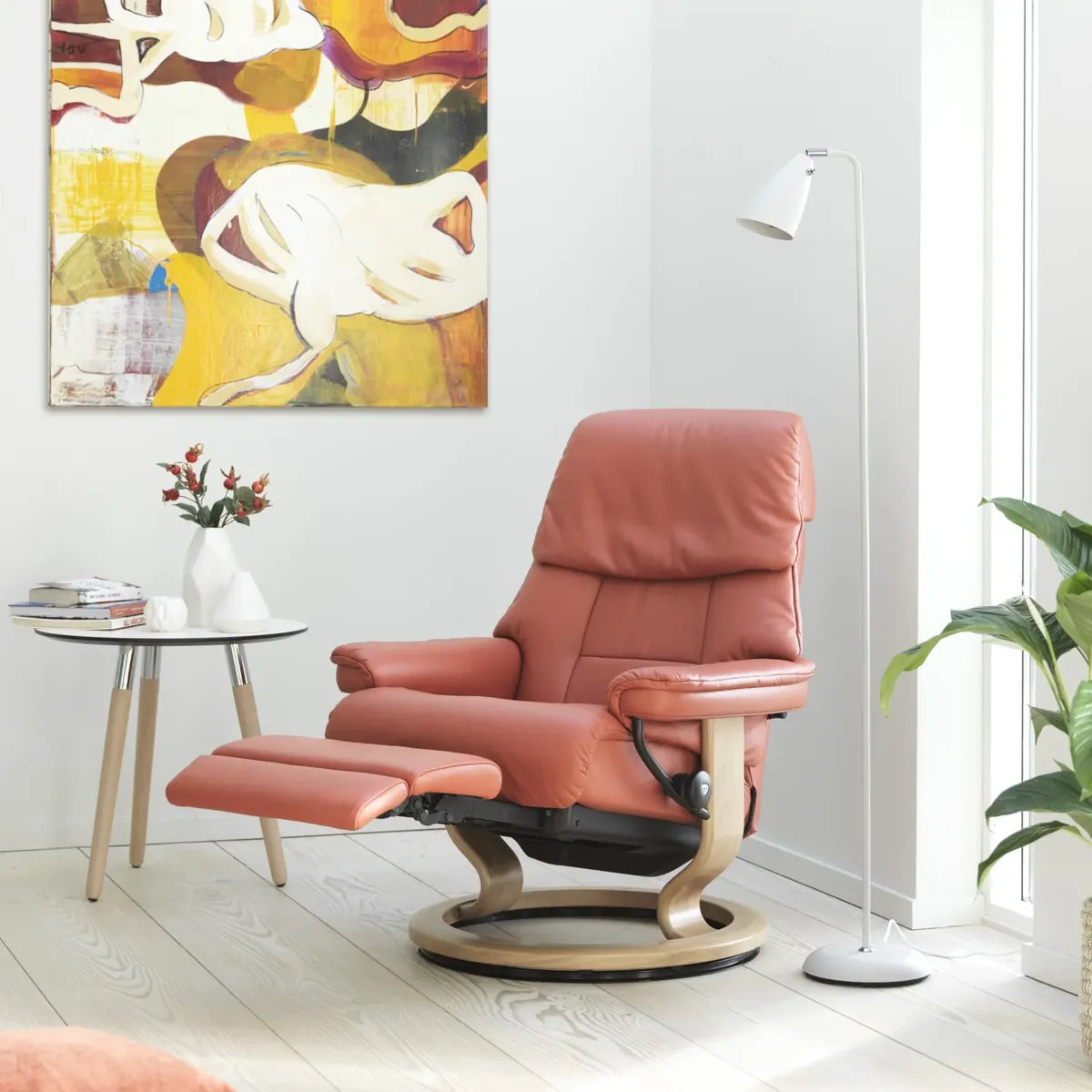 Stressless Ruby Power in koraalrood leder met uitgeschoven voetsteun op een Classic onderstel, in een lichte kamer