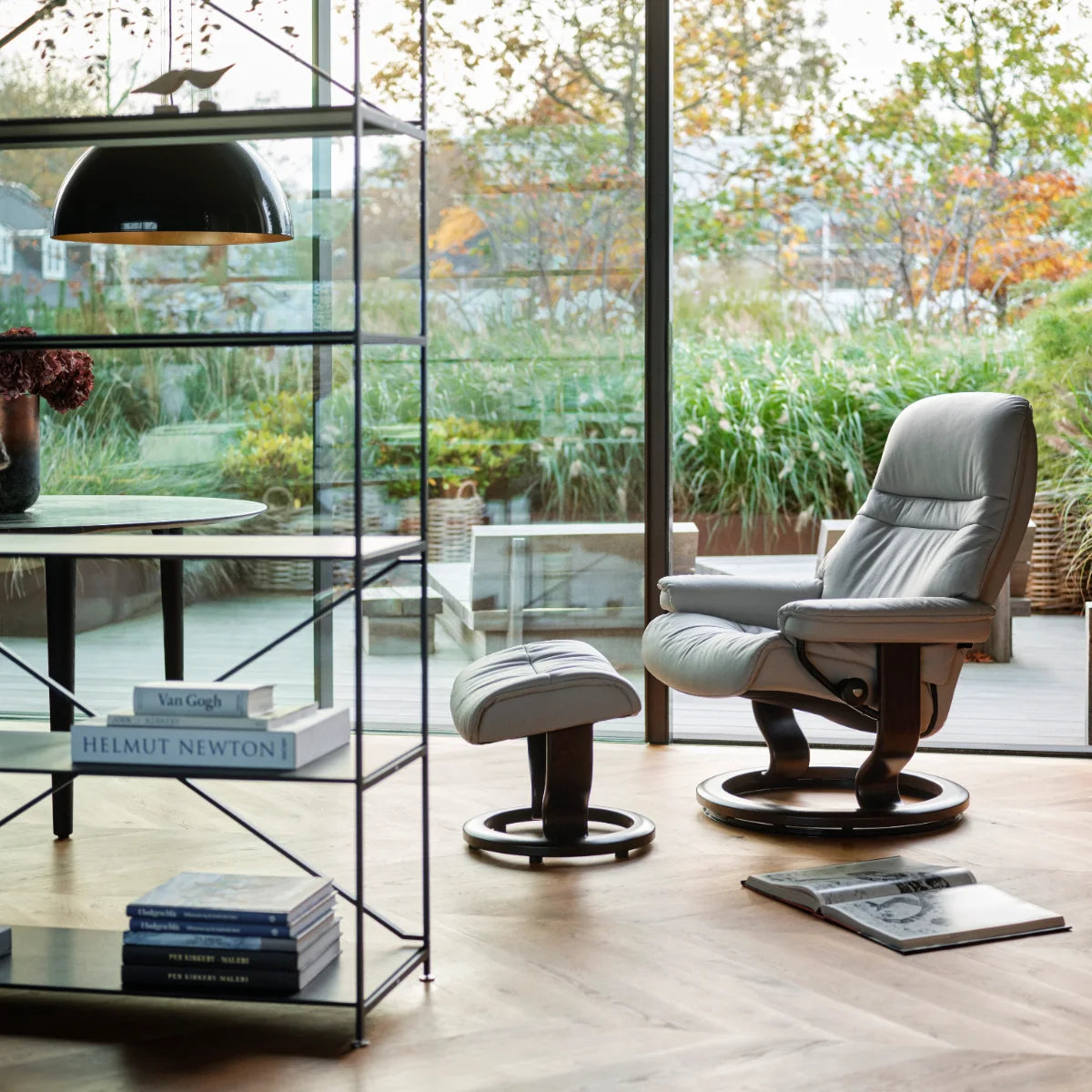 Stressless Sunrise in Platinum Grey Batick leder met voetenbank in een lichte serre met planten