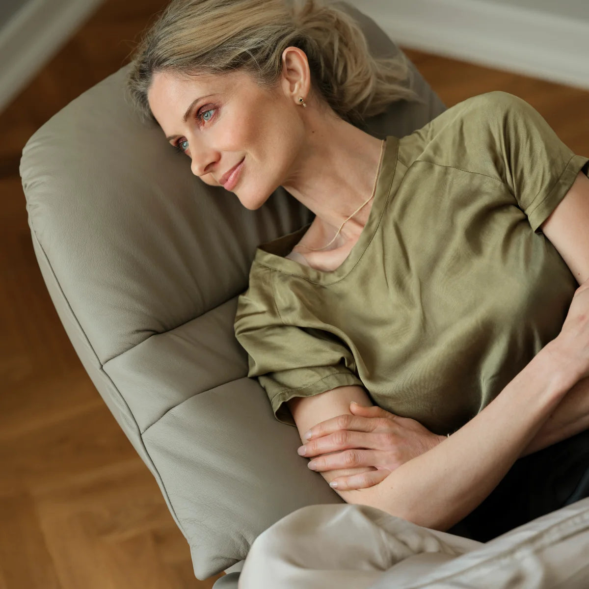 Vrouw ligt ontspannen op haar zij in een Stressless Sunrise in Paloma Mushroom leder